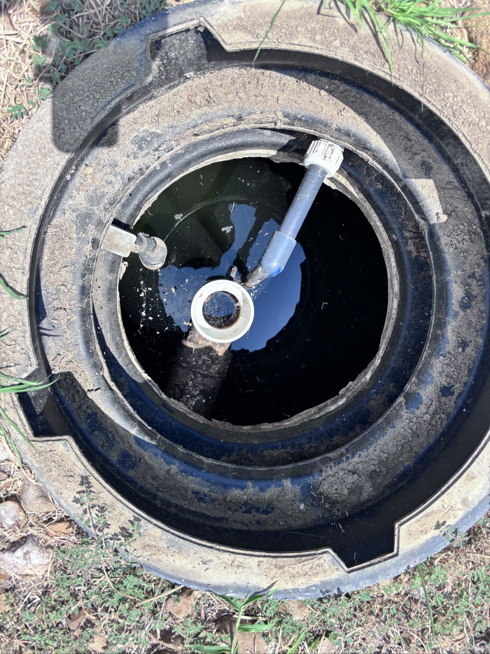 Open septic tank showing float switch and pipes during a Palm Bay Septic inspection