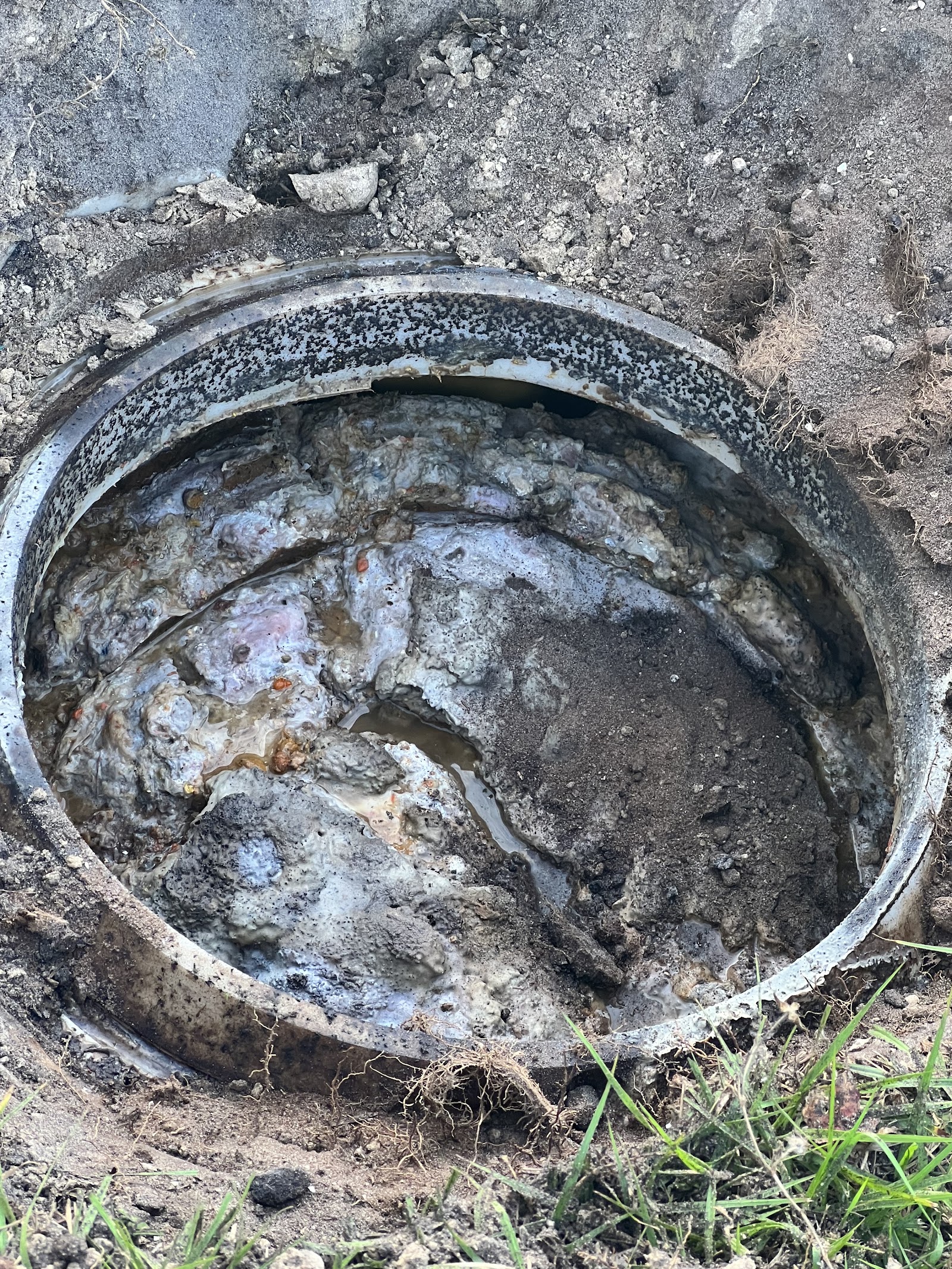 Septic tank opened during an inspection showing sludge and sediment buildup inside