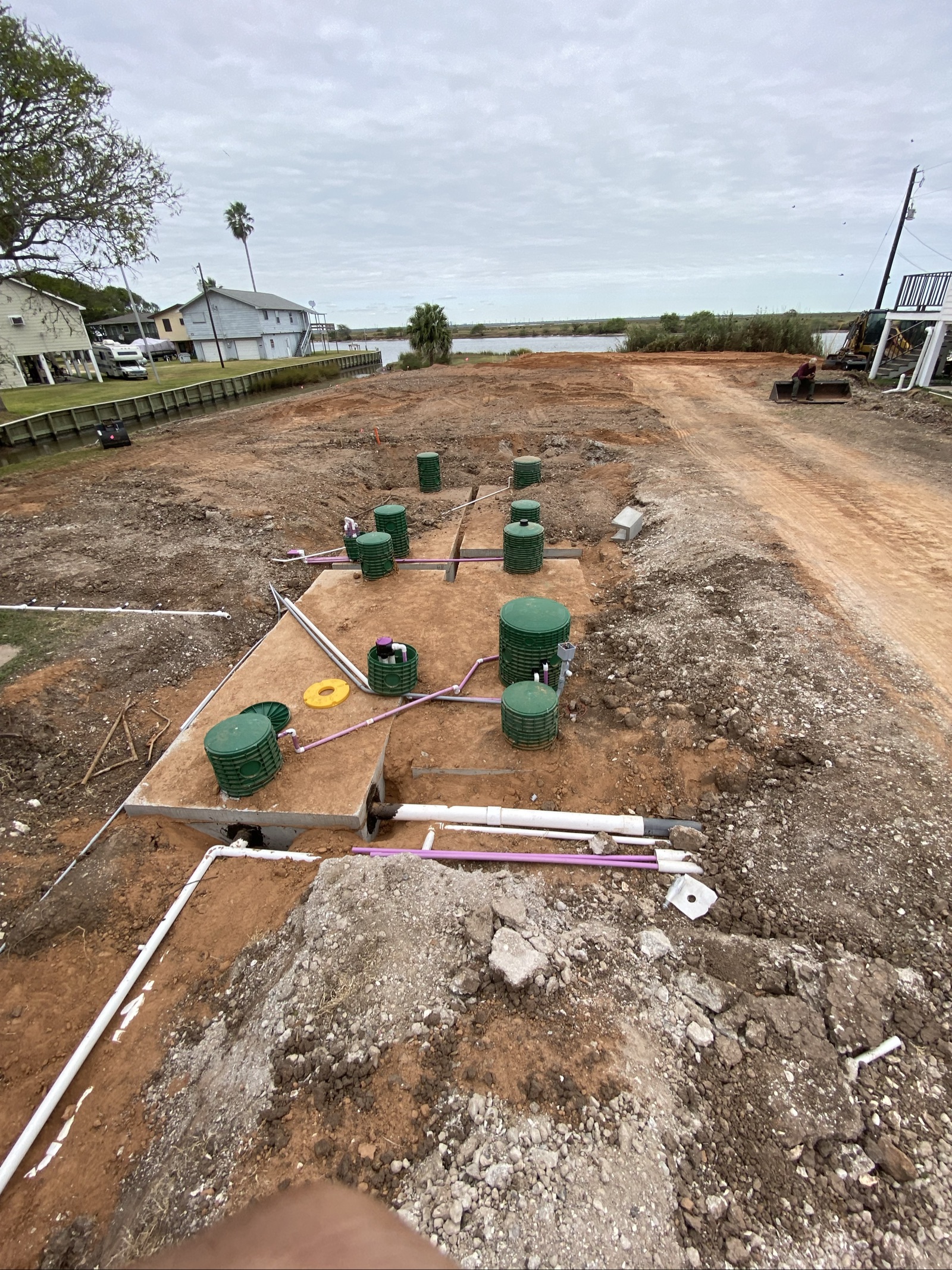 Aerobic septic system installation with multiple green tanks connected by pipes in residential yard