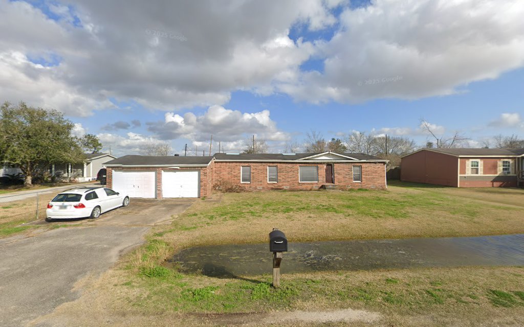 Single-story brick residential home with two-car garage and mailbox in front yard