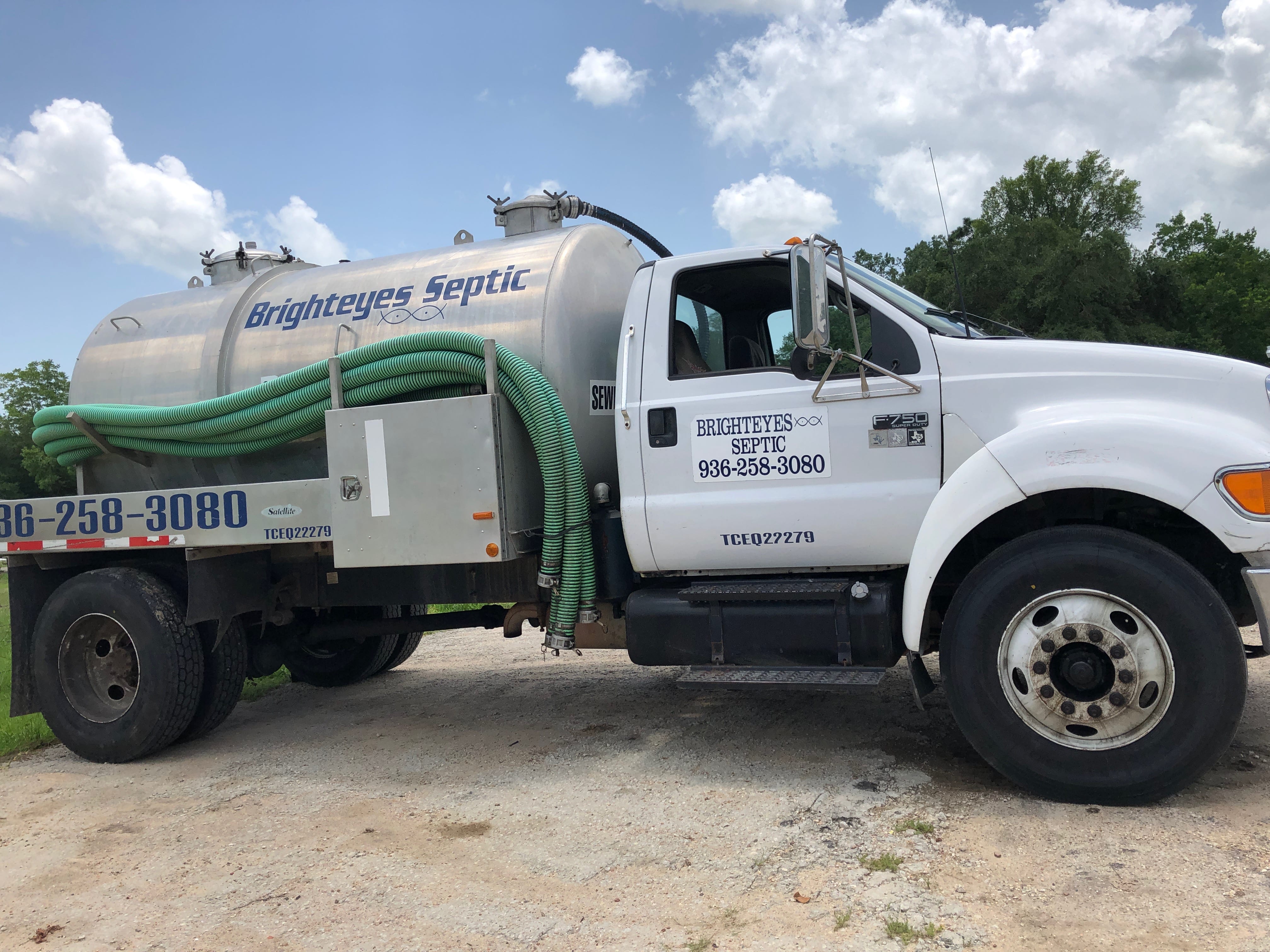 Brighteyes Septic white service truck with green hose attachment on gravel driveway